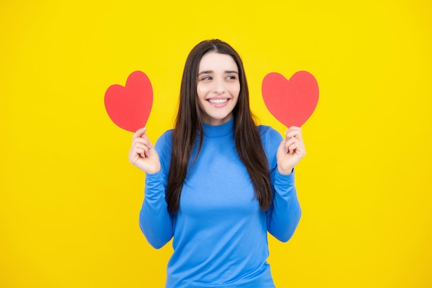 Liebeszeichensymbole für den Valentinstag oder den Geburtstag der glücklichen Frauen Schöne junge Frau mit Herz ihr