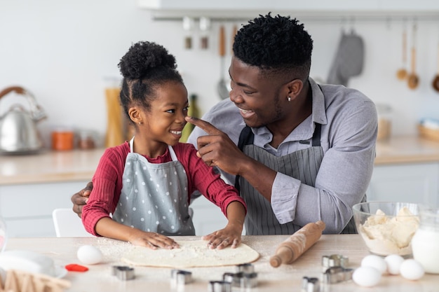 Liebevolle afroamerikanische Familie, die Spaß beim Backen zu Hause hat