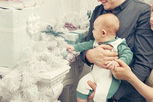Liebevolle Eltern zeigen ihre Babyweihnachtsgeschenke
