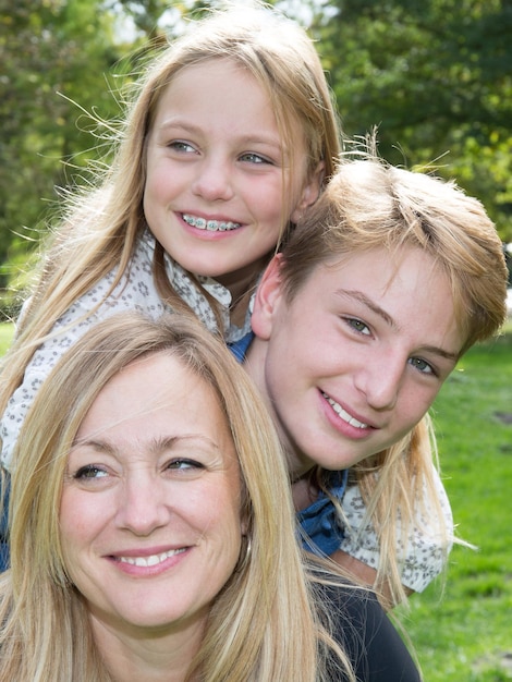 Foto liebevolle familie im freien auf dem gras in einem park mit lächelnden gesichtern