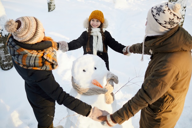 Liebevolle Familie um Schneemann