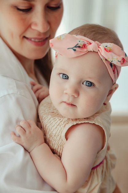 Liebevolle, glückliche Mutter, die zu Hause ein neugeborenes Baby trägt