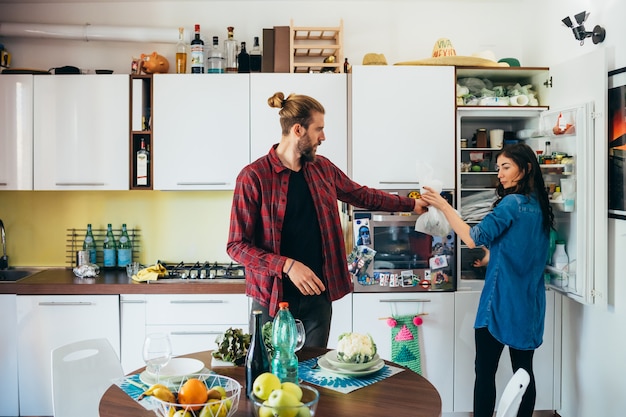 Liebevolle junge Paare, die zu Hause Lebensmittel in der Küche kochen