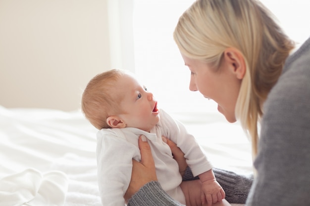 Liebevolle Mutter, die sie neugeboren hält