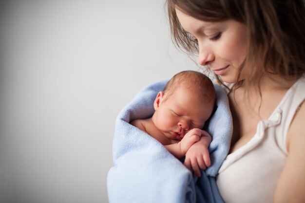 Liebevolle Mutter hält Neugeborenes Baby.