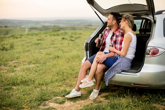 Liebevolle Paare, die im Autotrank sitzen