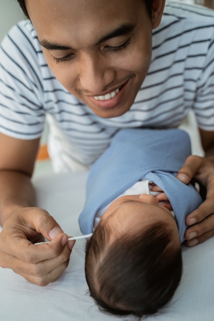 Liebevoller Vater putzte Babyohren