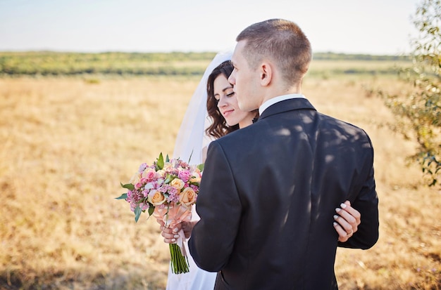 Liebevolles Hochzeitspaar im Freien