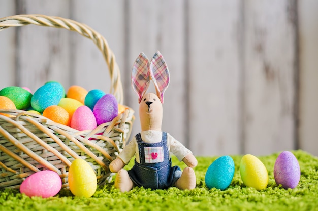 Liebre sentada en la hierba con huevos de Pascua