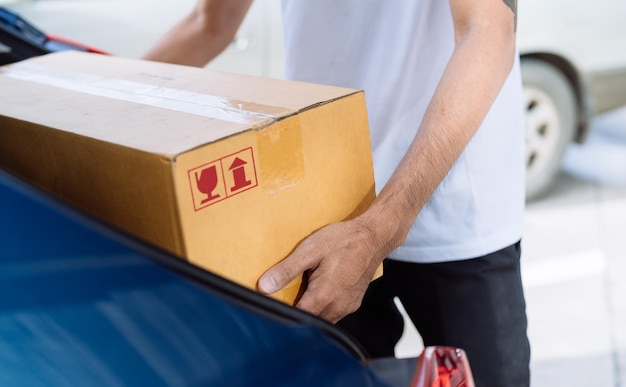 Lieferant, der eine Kartonschachtel trägt, die mit dem Transport an den Empfänger geschickt wird