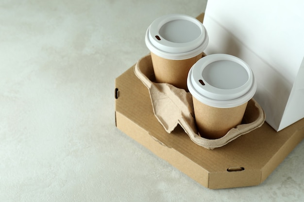 Lieferbehälter für Lebensmittel zum Mitnehmen auf weiß strukturiertem Tisch