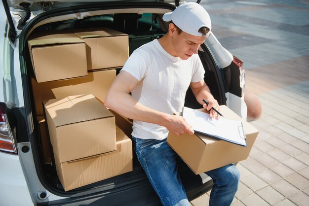 Lieferbote, der Box vom Auto abholt.
