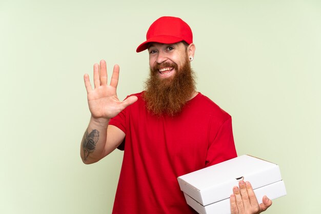 Lieferbote mit langem Bart begrüßend mit der Hand mit glücklichem Ausdruck