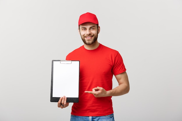 Lieferer in der roten Uniform, die weißes leeres leeres Papier lokalisiert auf weißem Hintergrund hält.