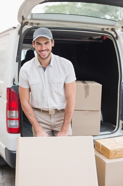 Lieferfahrer, der seinen Packwagen mit Kästen lädt