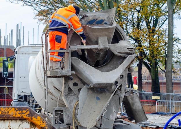 Lieferfahrer waschen Betonwagen nach der Betonlieferung auf der Baustelle