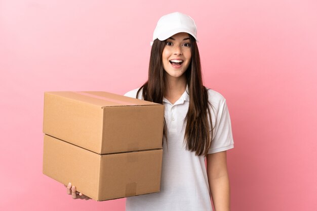 Liefermädchen über isolierter rosa Wand mit überraschendem Gesichtsausdruck