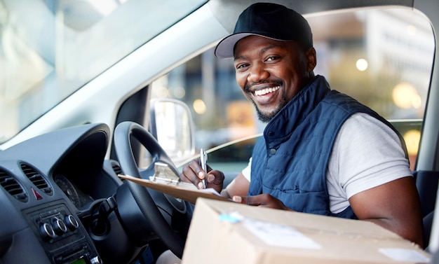 Liefermanntransport und Porträt eines Mannes, der mit einem Lächeln im Fenster für den Versand oder Kurierdienst schreibt. Fröhliche schwarze Person oder Fahrer mit Papppaket zum Unterschreiben von Papier in einem Lieferwagen oder Frachtfahrzeug