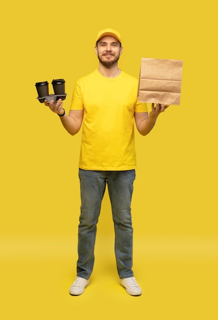 Foto lieferservice, fast food und people-konzept - glücklicher mann mit kaffee und einweg-papiertüte.