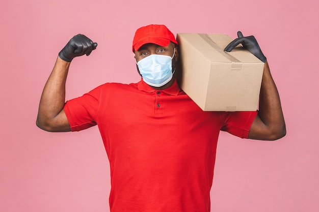 Lieferung Afroamerikaner Mann Mitarbeiter in roter Kappe leer T-Shirt Uniform Gesichtsmaske Handschuhe halten leere Pappschachtel