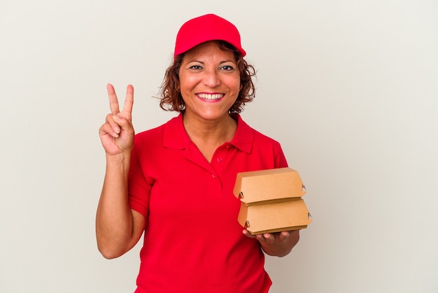 Lieferung Frau mittleren Alters unter Burger isoliert auf weißem Hintergrund zeigt Nummer zwei mit den Fingern.