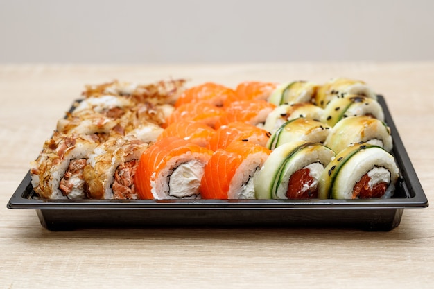 Lieferung von Sushi nach Hause in einer Plastikbox.