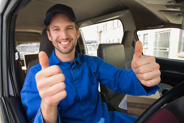 Lieferungsfahrer, der an der Kamera in seinem Packwagen lächelt