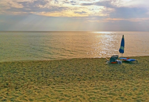 Liege und Sonnenschirm am Strand des griechischen Mittelmeers