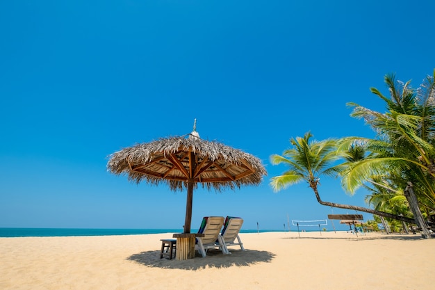 Foto liegestühle und sonnenschirm auf dem sand des tropischen strandes