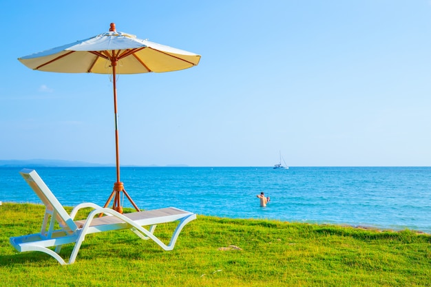 Liegestühle und Sonnenschirme stehen auf der Liegewiese am Strand.