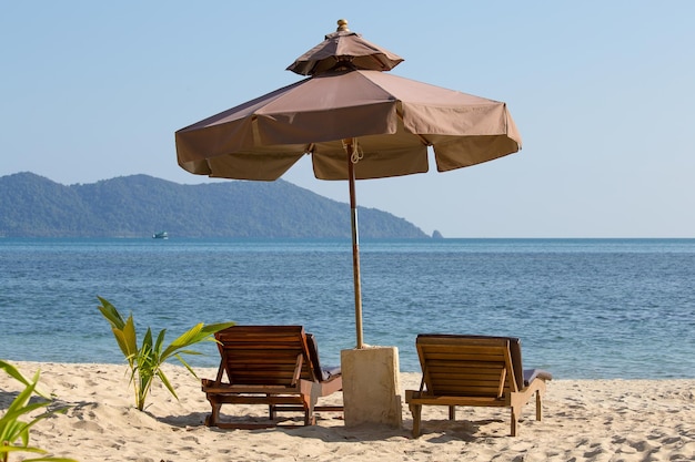 Liegestuhl und Sonnenschirm am Strand am sonnigen Tag Thailand