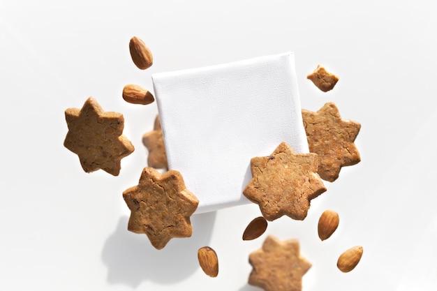 Lienzo con espacio de texto volando levitando con galletas estrella almendras Grupo de sabrosos bocadillos alrededor del tablero de texto Aislado en blanco Maqueta de comida creativa para sus letras de saludo