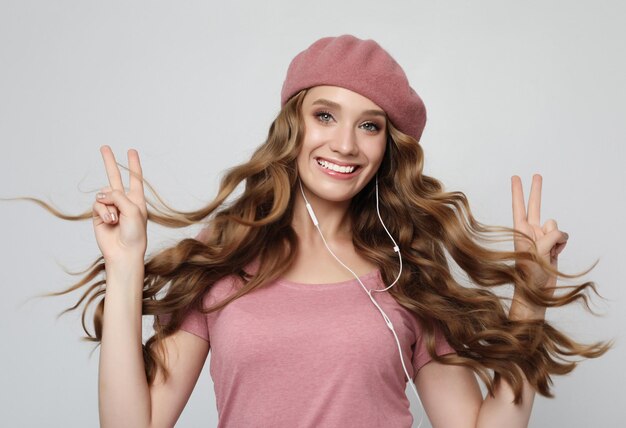 Lifestyle-Emotionen und People-Konzept Schönes Mädchen mit langen, welligen Haaren, das Musik hört