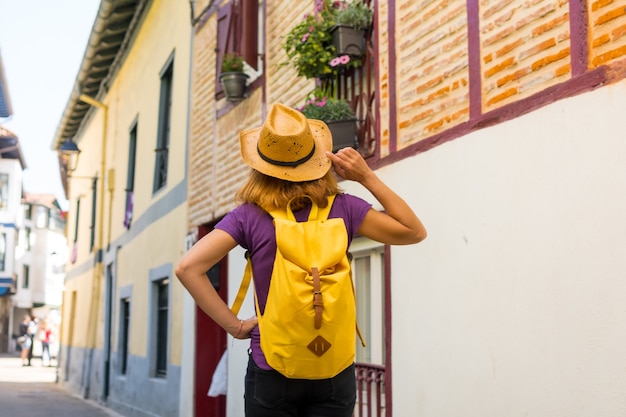 Lifestyle, un excursionista aventurero con una mochila amarilla visitando un pueblo rural tradicional, espacio para copiar y pegar, Municipio de Ea en el País Vasco