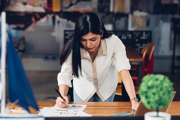 Lifestyle freiberufliche frau und laptop untersuchte er das grafikgewinndokument im café