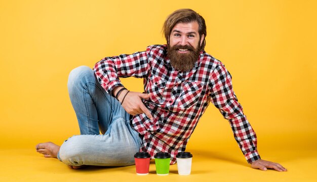 Lifestyle-Konzept Gutaussehender Hipster-Mann mit einer Tasse Kaffee zum Mitnehmen Er macht eine Kaffeepause Schöner reifer Kerl, der aus der Tasse trinkt Halten Sie eine Tasse Kaffee oder Tee