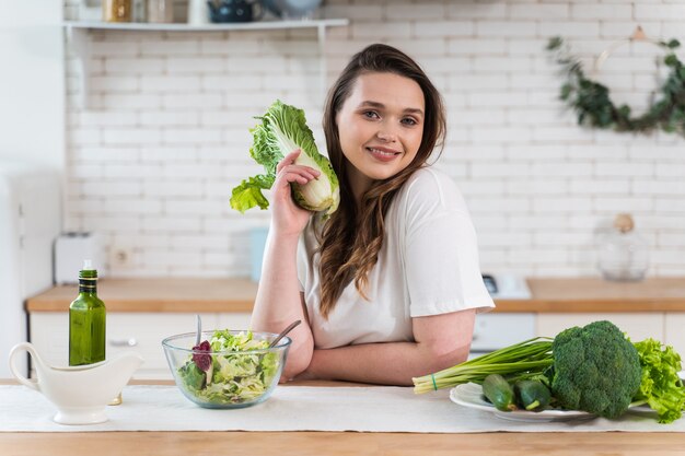 Lifestyle-Momente einer jungen Frau zu Hause. Frau bereitet einen Salat in der Küche zu