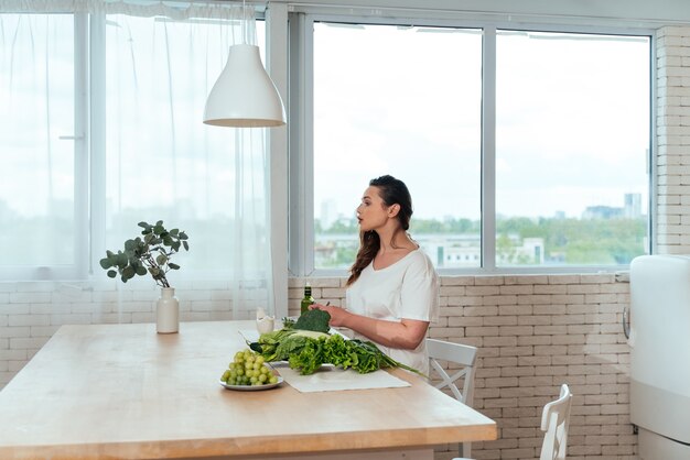 Lifestyle-Momente einer jungen Frau zu Hause. Frau bereitet einen Salat in der Küche zu