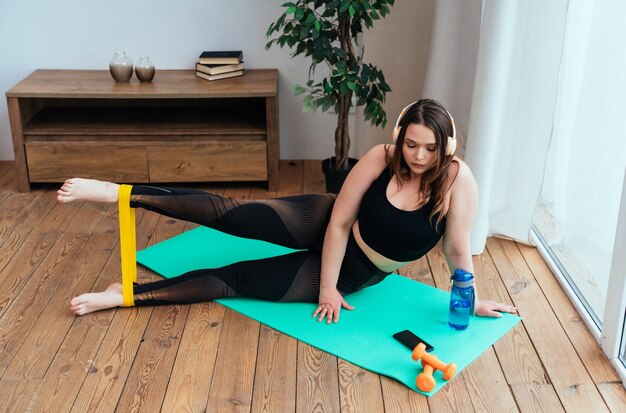 Lifestyle-Momente einer jungen Frau zu Hause. Frau macht Sportübungen im Wohnzimmer