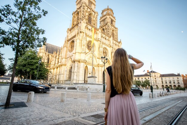 Lifestyle-Porträt einer Frau, die während des Sonnenuntergangs in Orleans, Frankreich, in der Nähe der berühmten Kathedrale spaziert