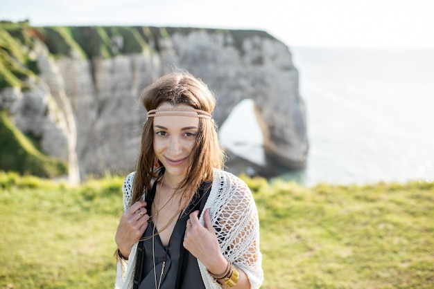 Lifestyle-Porträt einer jungen Frau im Hippie-Stil, die die Natur an der felsigen Küste mit herrlichem Blick auf das Meer in Frankreich genießt