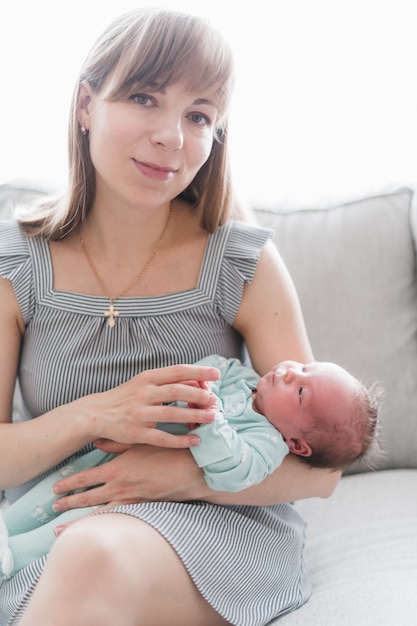 Lifestyle-Porträt einer jungen Mutter und ihrer neugeborenen, drei Wochen alten Tochter.