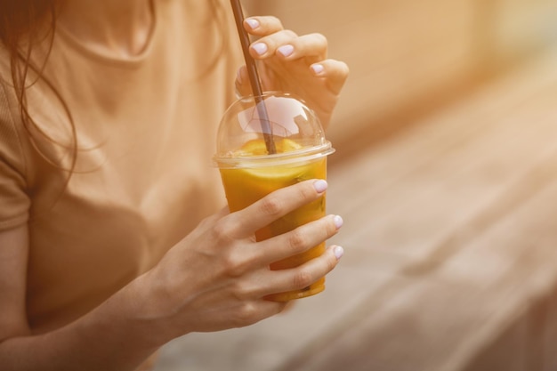 Lifestyle-Porträtfrau mit Tasse Saft Hipster-Mädchen hält einen Smoothie in ihren Händen