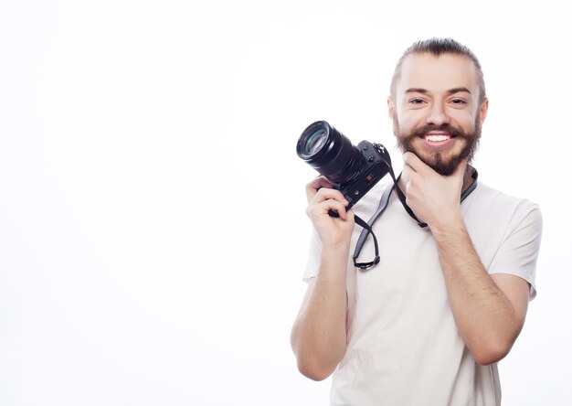 Lifestyle-Technologie und Reisekonzept Bärtiger Mann mit weißem T-Shirt und einer Digitalkamera isoliert auf weißem Hintergrund