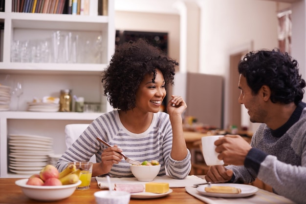 Ligação no café da manhã Foto de um casal feliz tomando café da manhã juntos