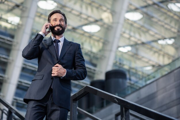 Ligue de volta. Ângulo baixo de um empresário barbudo otimista conversando ao telefone