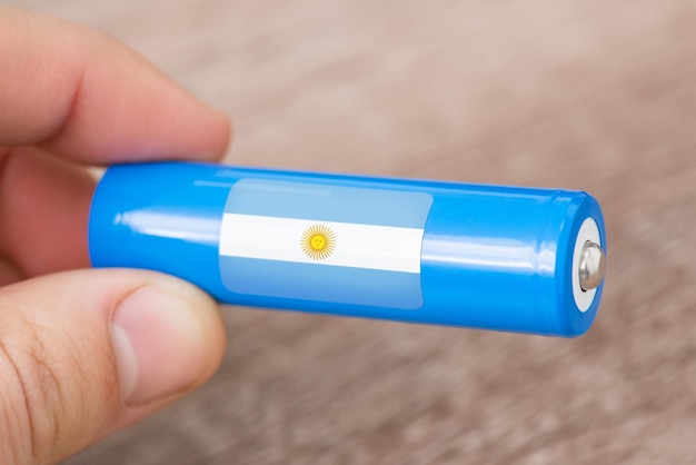 Liion-Batterie mit argentinischer Flagge in der Hand des Mannes Produktion von Batterien in Argentinien Konzept