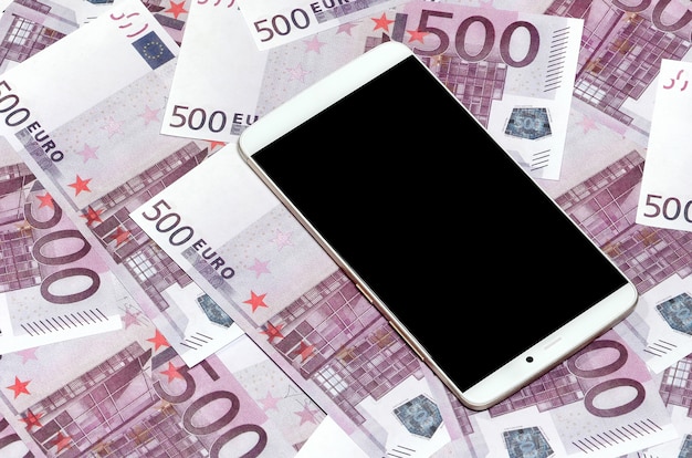 Lila 500-Euro-Geldscheine und ein Smartphone mit schwarzem Bildschirm.