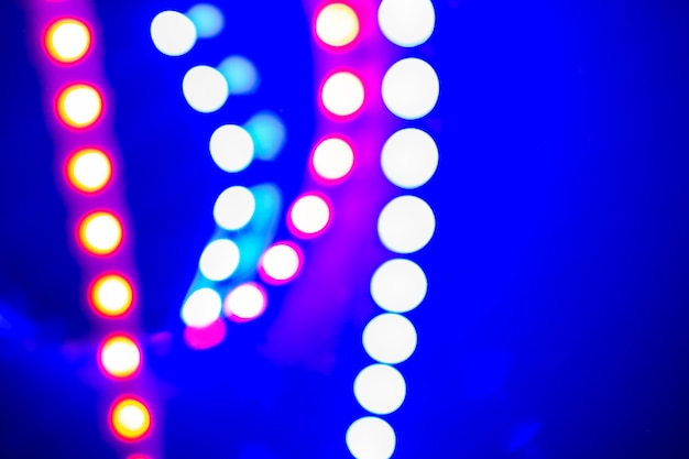 Lila blaue Neon-Bokeh-Lichter und Reflexionen. Festlicher abstrakter Hintergrund der Farben der 80er Jahre.