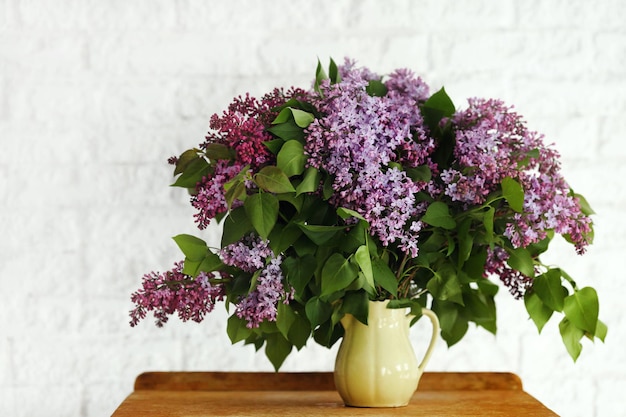 Lila Blume in einer Vase auf einem hölzernen Hintergrund